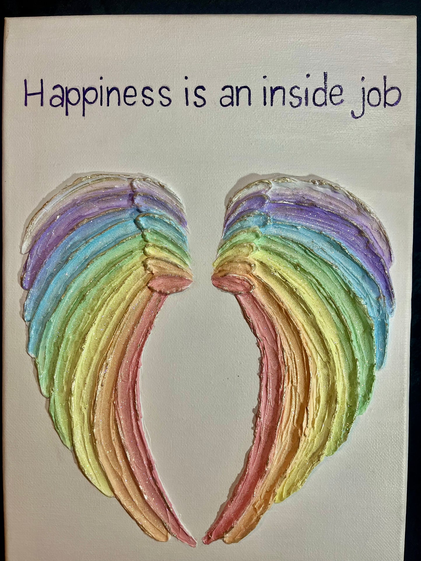 Rainbow/Chakra angel wings with a motivational quote on a plain background