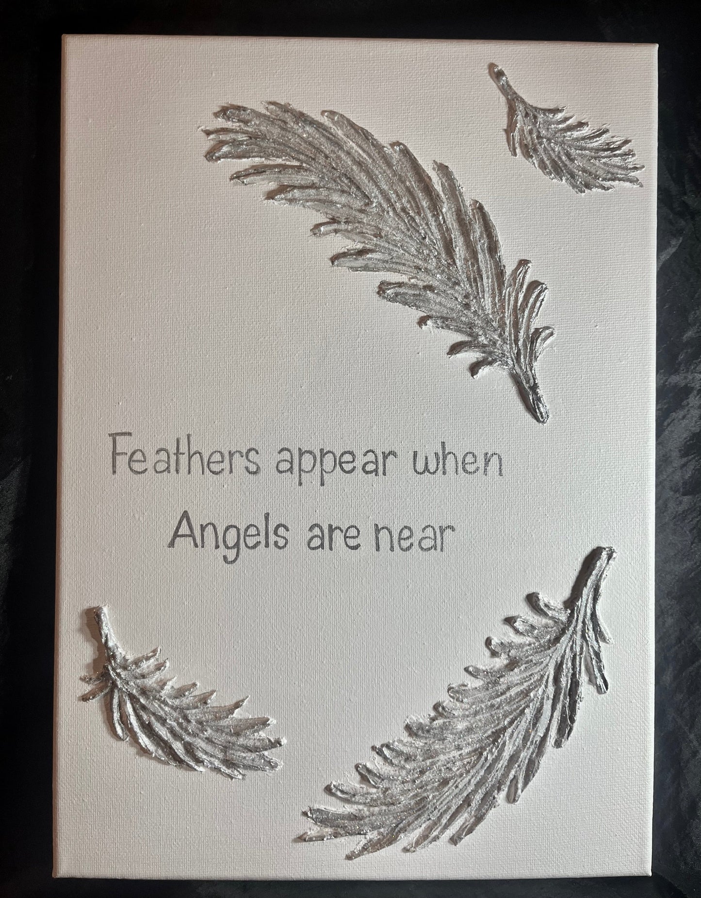 Decorative panel with feather designs and text on a white background